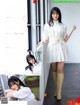 A woman in a white dress and knee high boots posing for a magazine.