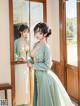 A woman in a blue kimono standing in front of a mirror.